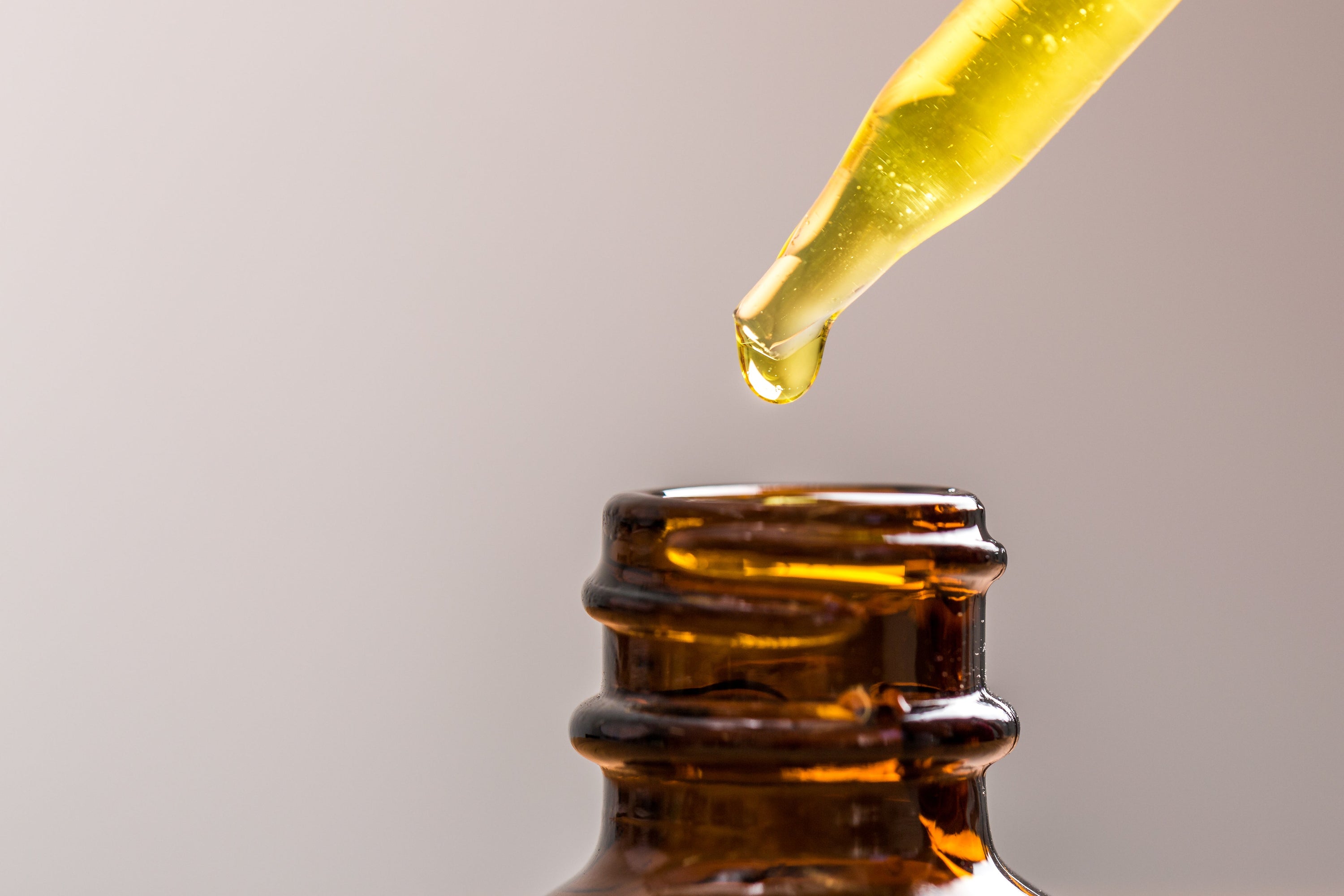 Amber bottle with a dropper full of yellow oil